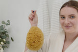 Naturschwamm im Badezimmer auf dem Rand der Badewanne zur täglichen Körperpflege