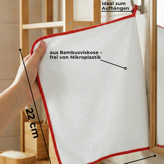 Infografik: Bambus-Putztuch mit roter Kante, Maße 22 x 18 cm, hängt an der Aufhängeschlaufe am Haken im Bad